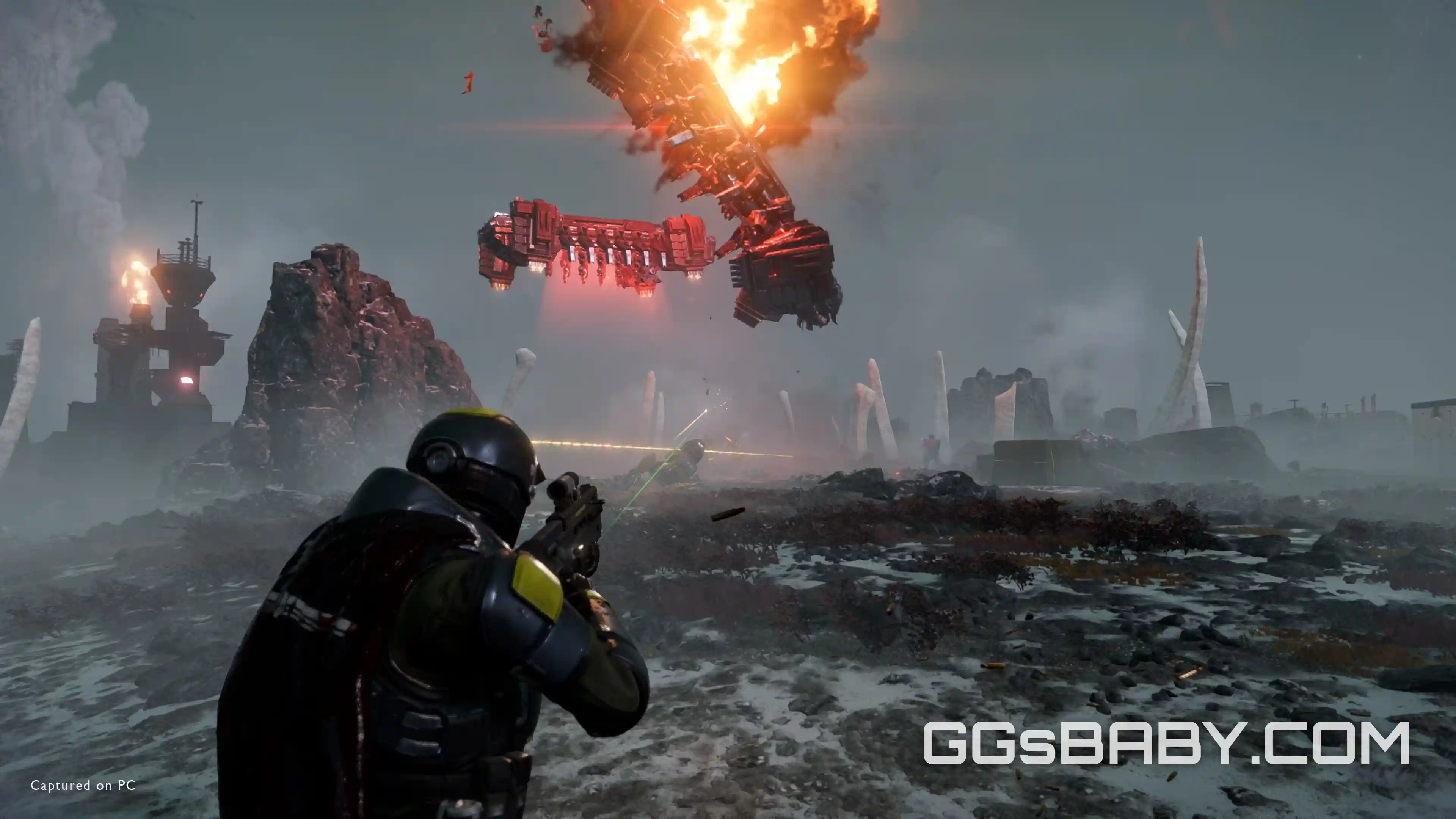 Helldiver aiming rifle at a burning Automaton dropship crashing on a foggy planet via ggsbaby.com